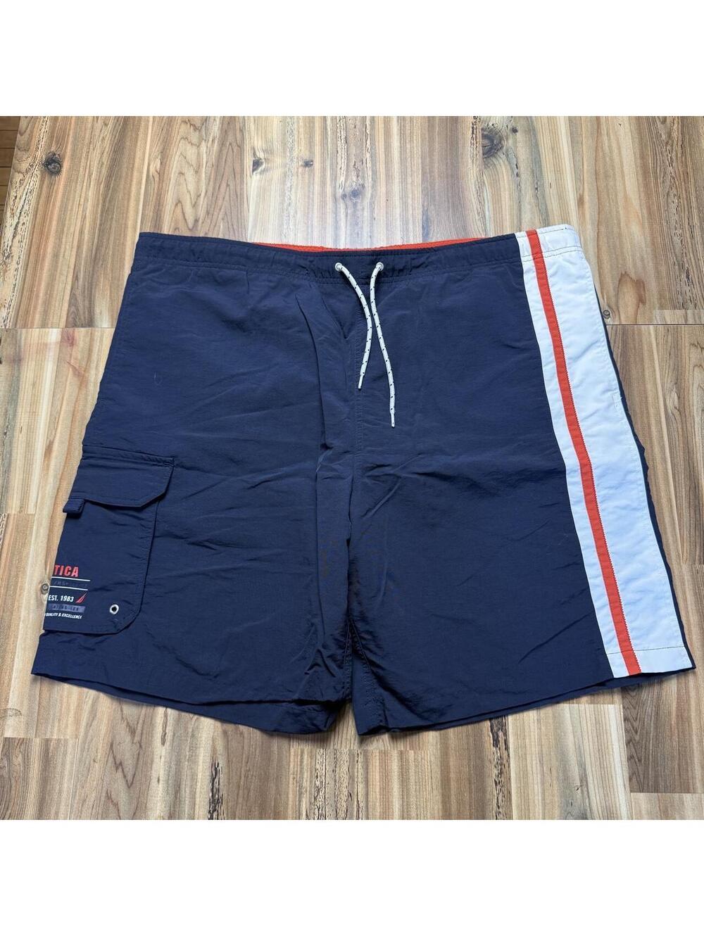 Nautica navy blue swim trunks with white and red stripes on the side,